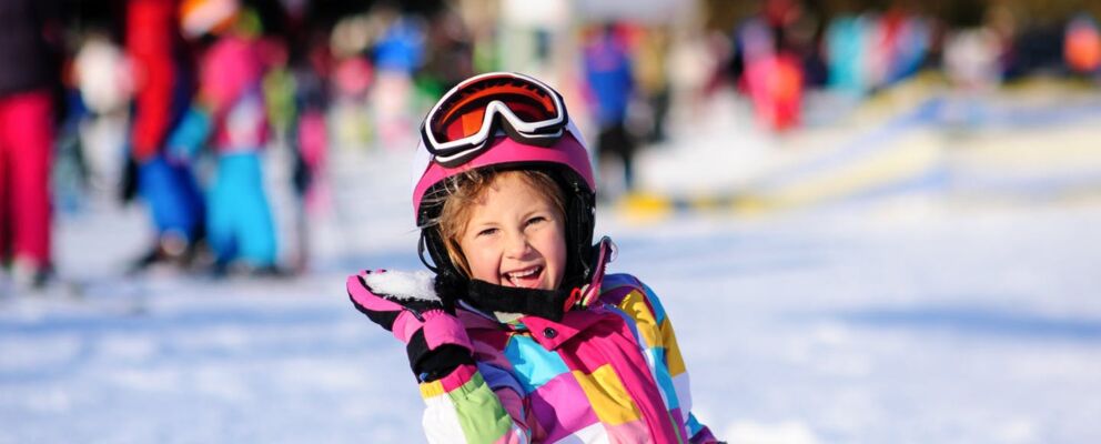 Child playing in the snow at Dinner Plain with Hoys rental snow gear on including goggles, helmet and outerwear.