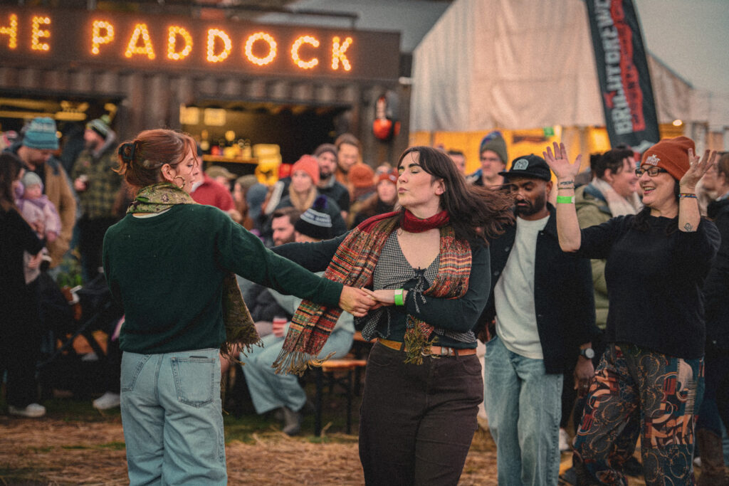 Folks enjoying a dance to the live music at the Darker Days Festival with bar in the background